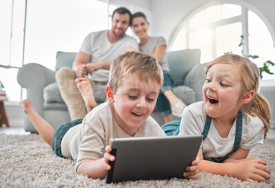 Buy stock photo Shot of a little brother and sister using a digital tablet together at home