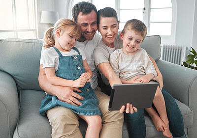 Buy stock photo Shot of a young family using a digital tablet at home