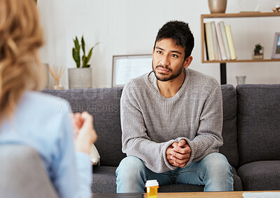 Buy stock photo Shot of a young man having a therapeutic session with a psychologist