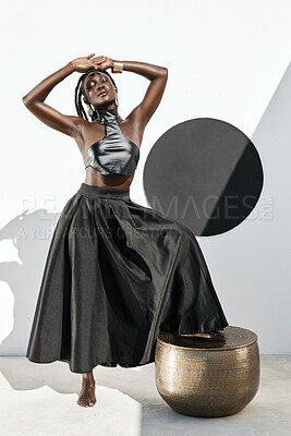 Buy stock photo Shot of an attractive young woman posing in a black outfit against a wall with a circle on it