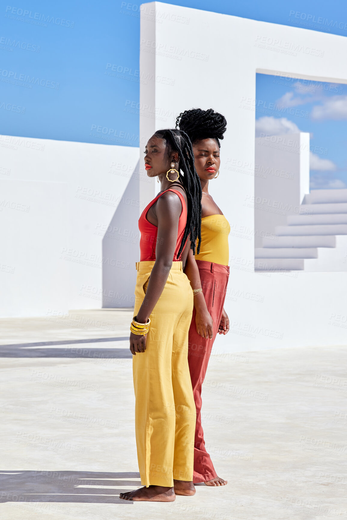 Buy stock photo Full length shot of two attractive young women posing on a rooftop outdoors