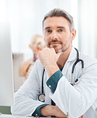 Buy stock photo Portrait of a mature doctor working on a computer in a medical office