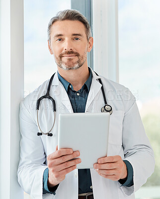 Buy stock photo Shot of a mature doctor using a tablet in a office