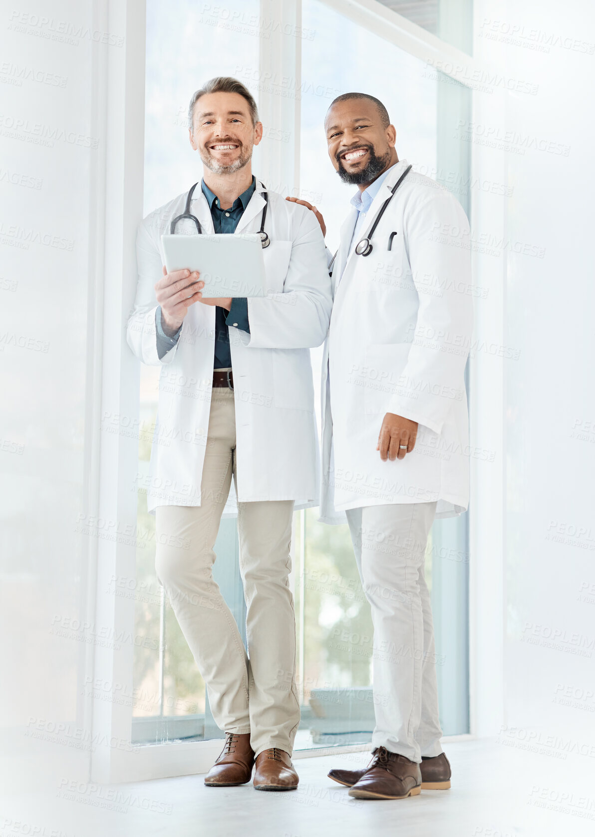 Buy stock photo Shot of two mature doctors using a tablet in a office