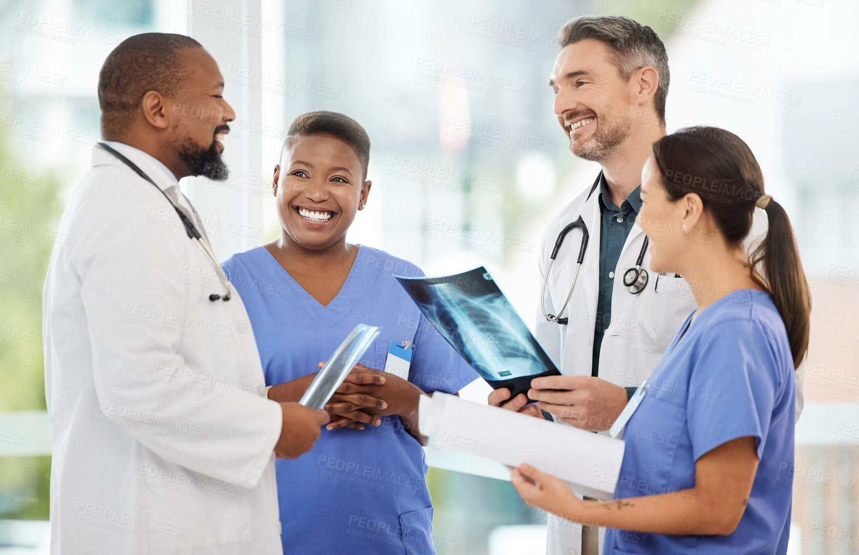 Buy stock photo Shot of a group of medical practitioners analysing x-rays in a hospital