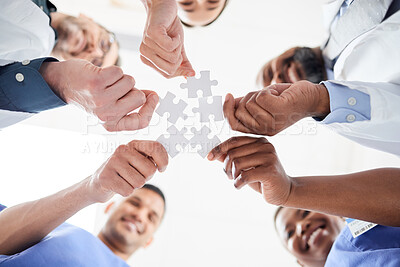 Buy stock photo Closeup shot of a group of medical practitioners holding puzzle pieces