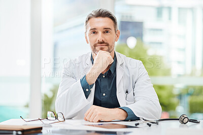 Buy stock photo Shot of a senior doctor sitting alone in his clinic