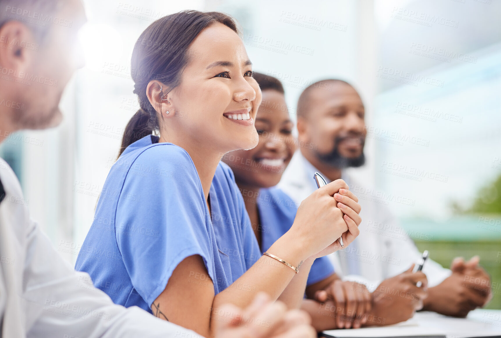 Buy stock photo Shot of a doctor sitting alongside his colleagues during a meeting in a hospital boardroom