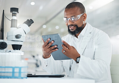 Buy stock photo Shot of a male scientist using a digital tablet while working in a lab