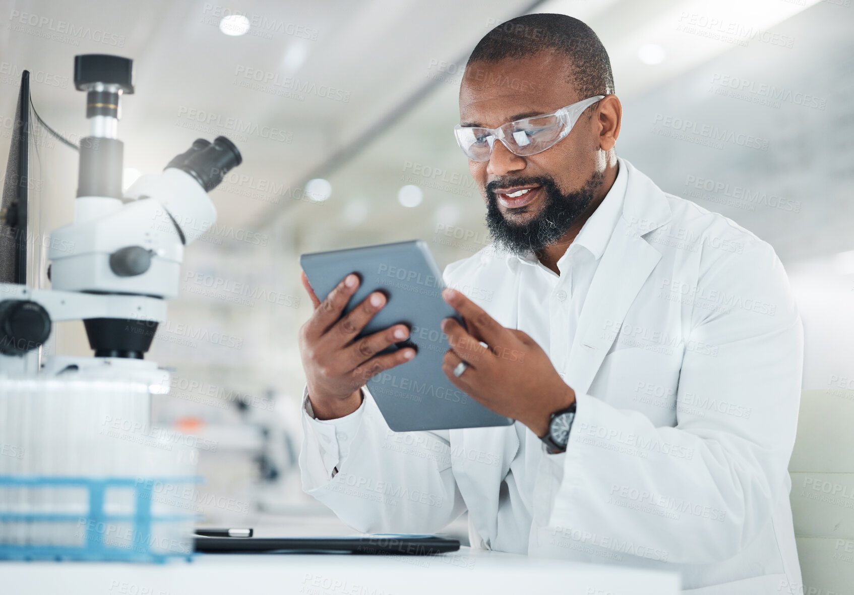 Buy stock photo Shot of a male scientist using a digital tablet while working in a lab