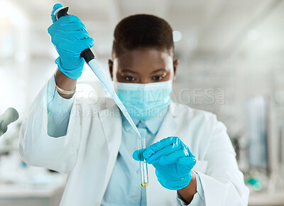 Buy stock photo Shot of a young scientist sitting alone in her laboratory and testing urine