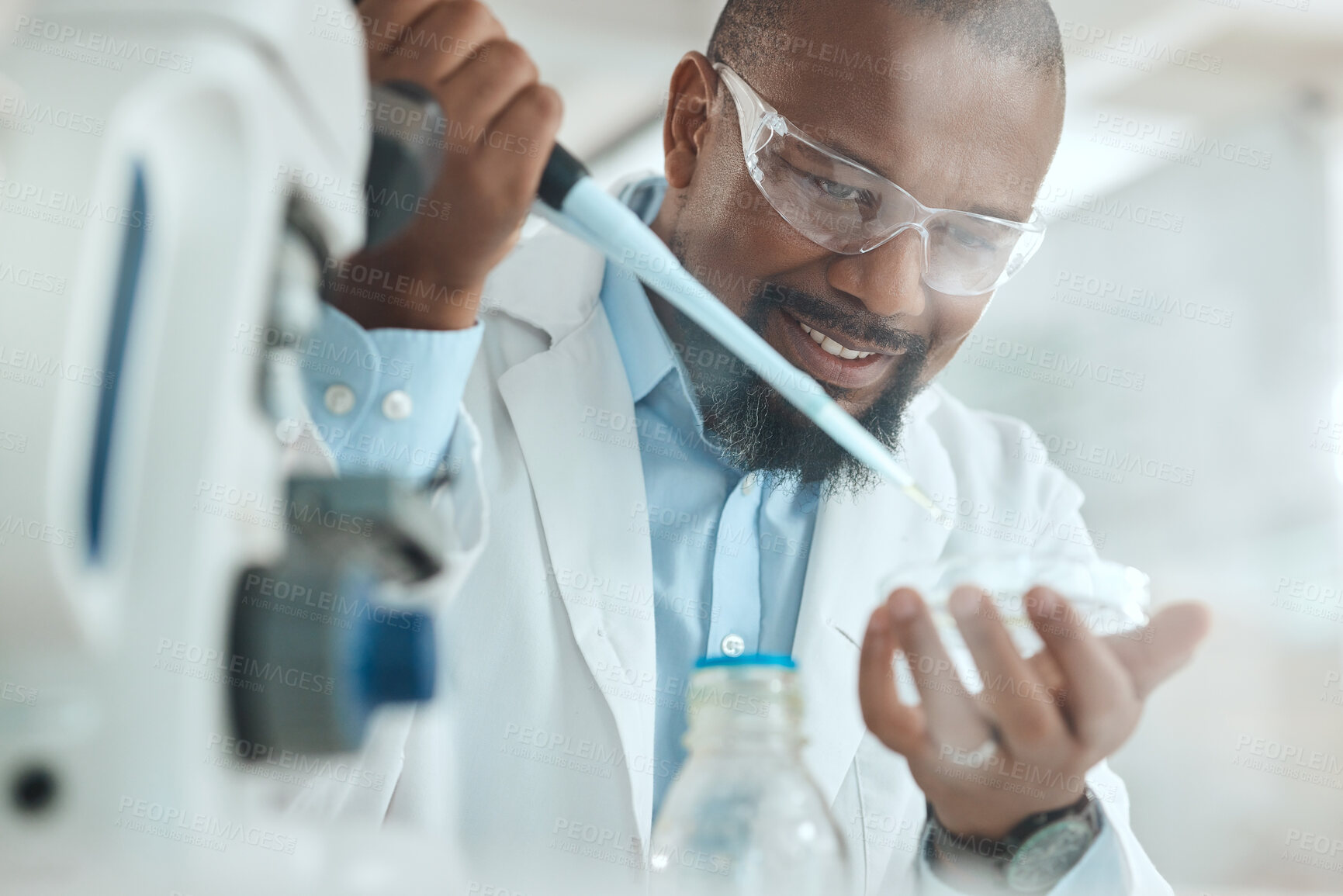 Buy stock photo Shot of a handsome mature scientist sitting alone in his laboratory and testing urine