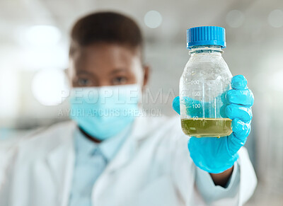 Buy stock photo Shot of an unrecognisable scientist holding a bottle of liquid for testing in her laboratory