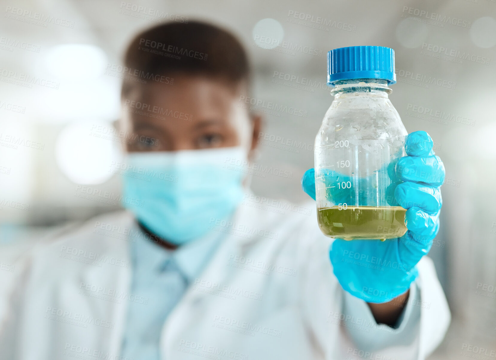 Buy stock photo Shot of an unrecognisable scientist holding a bottle of liquid for testing in her laboratory