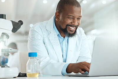 Buy stock photo Shot of a handsome mature scientist sitting alone in his laboratory and using his laptop