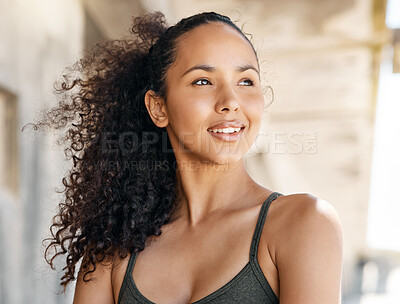 Buy stock photo Shot of an attractive young woman standing alone in the city and looking contemplative during her outdoor workout