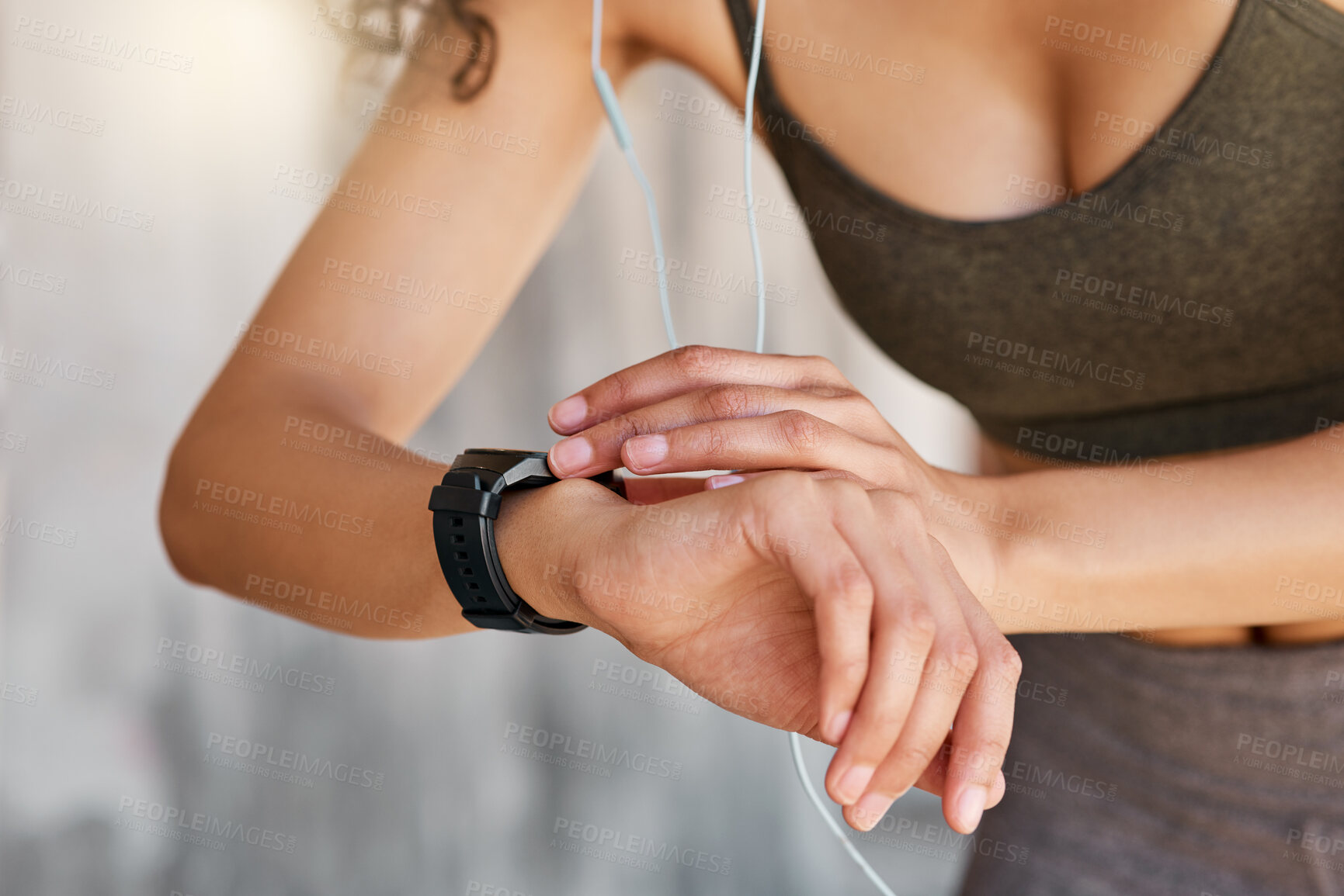 Buy stock photo Cropped shot of an unrecognisable woman using her watch during her outdoor workout in the city