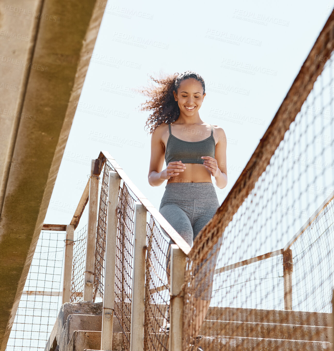 Buy stock photo Shot of an attractive young woman running down stairs during her outdoor workout in the city