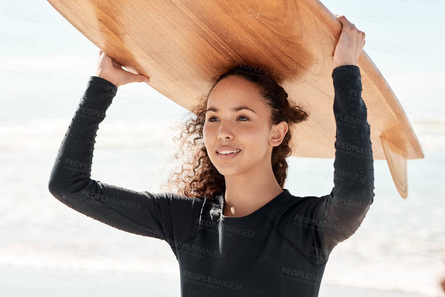 Buy stock photo Shot of an attractive young woman carrying a surfboard at the beach