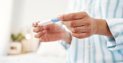 Buy stock photo Shot of an unrecognizable woman holding a pregnancy test at home