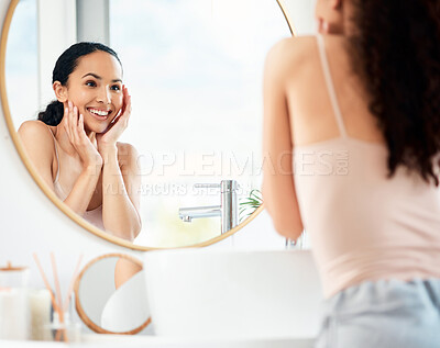 Buy stock photo Shot of a young woman admiring her skin in a bathroom at home