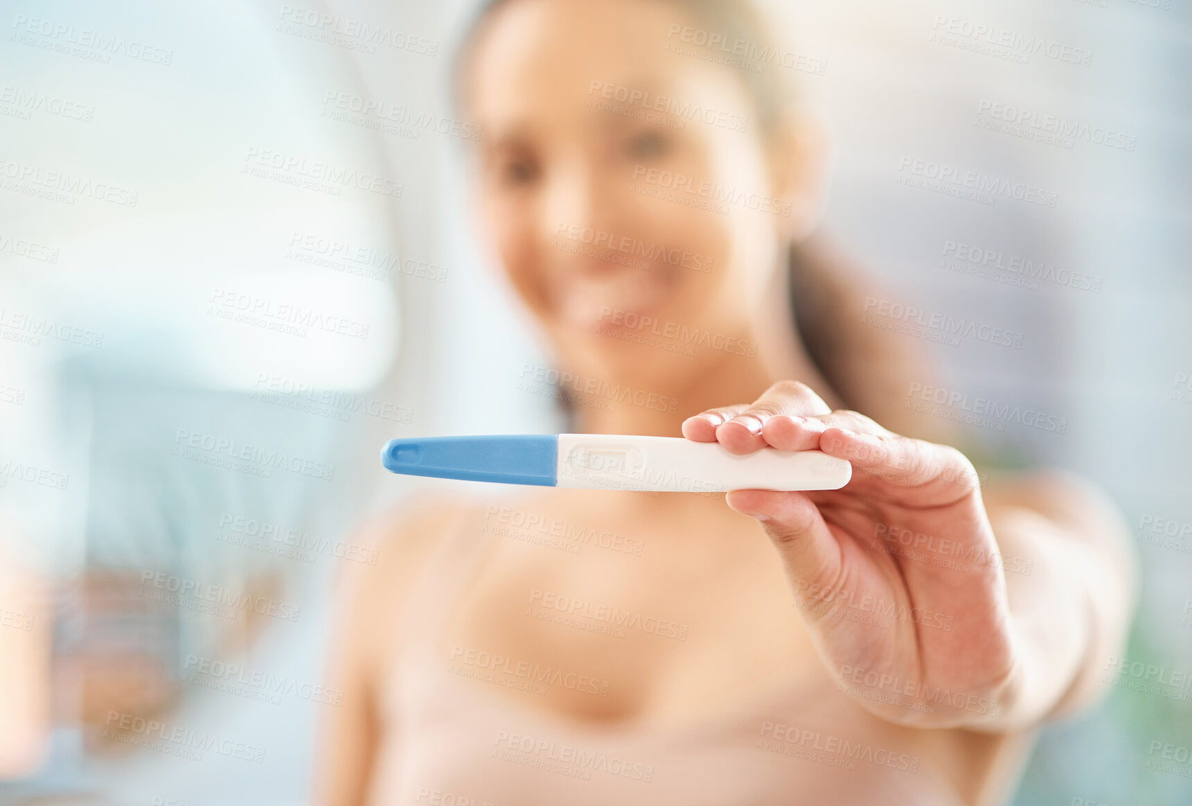 Buy stock photo Shot of an unrecognizable woman holding a pregnancy test at home