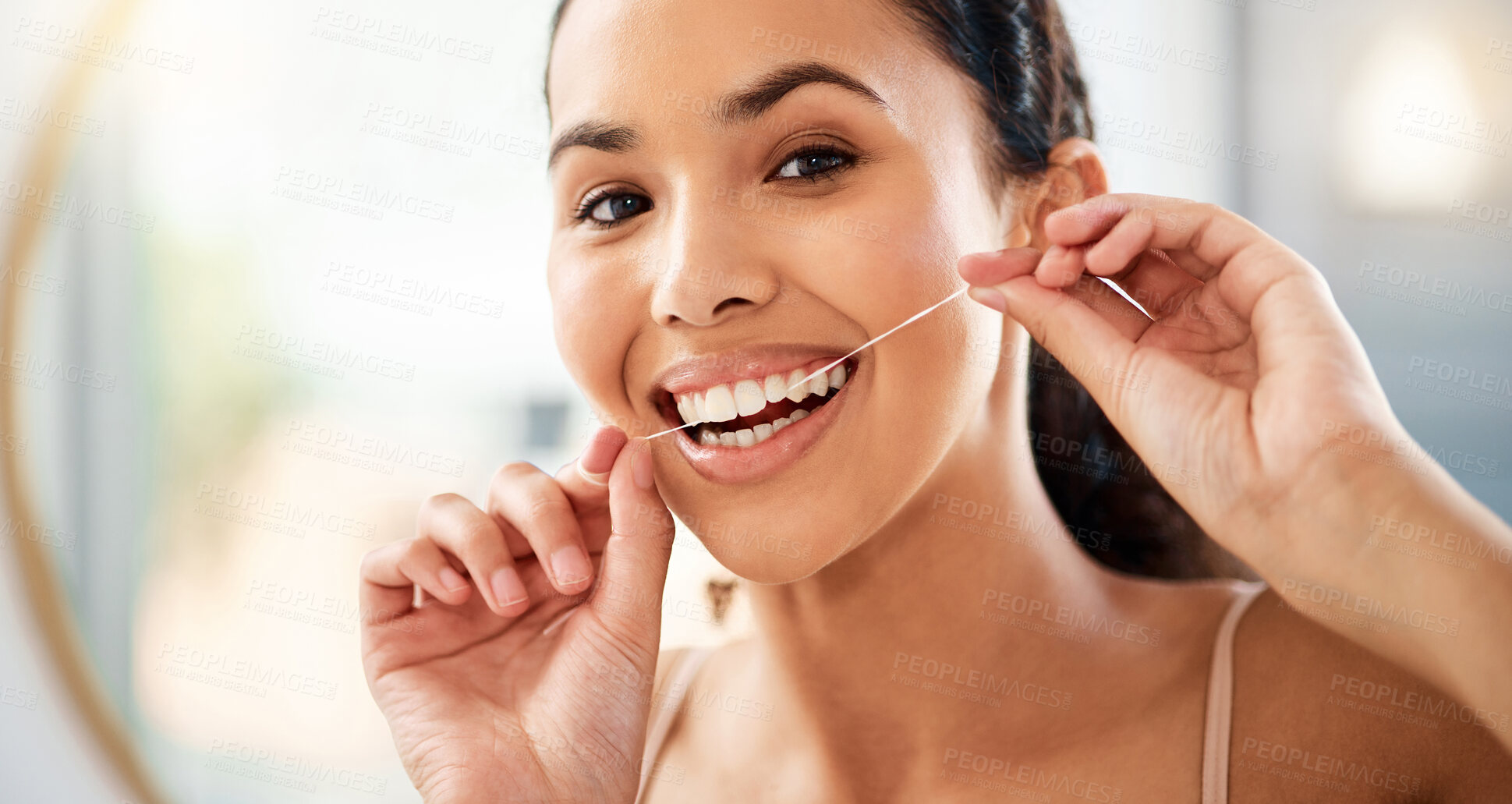 Buy stock photo Shot of a young woman flossing her teeth at home