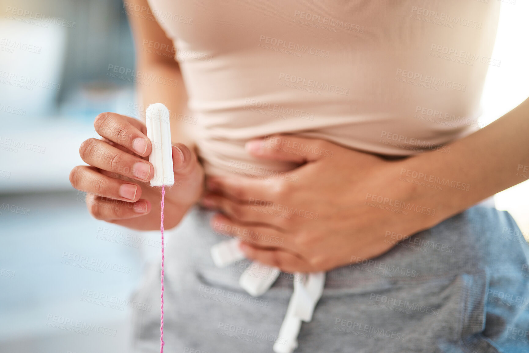 Buy stock photo Shot of an unrecognizable woman holding feminine hygiene products in a bathroom at home