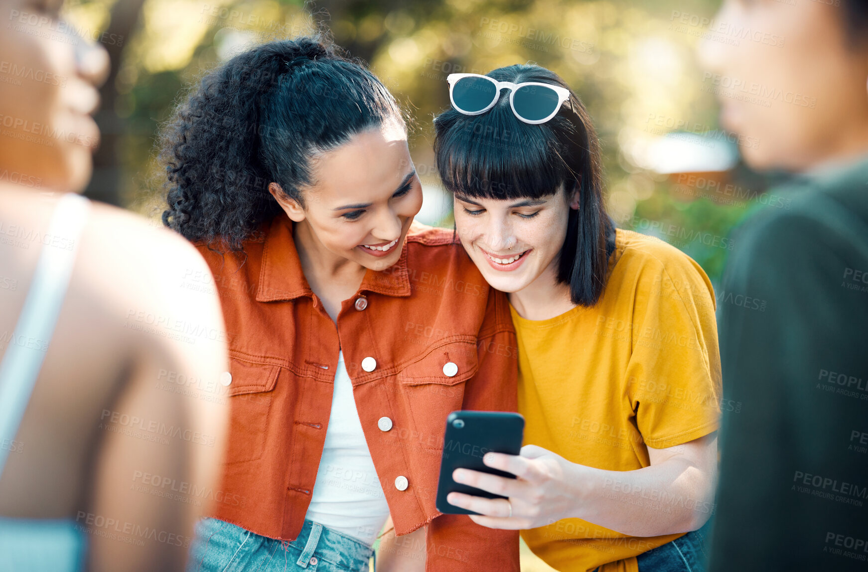 Buy stock photo Smile, friends and relax with phone at park for weekend break, check online gossip or social media. Mobile app, happy women and show text message outdoor for status update, blog news and reading chat