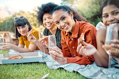 Buy stock photo Shot of a group of friends having champagne and pizza in a park