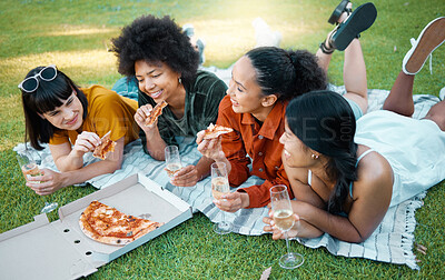 Buy stock photo Shot of a group of friends having champagne and pizza in a park