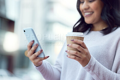 Buy stock photo Shot of a young businesswoman having coffee and using a smartphone against an urban background