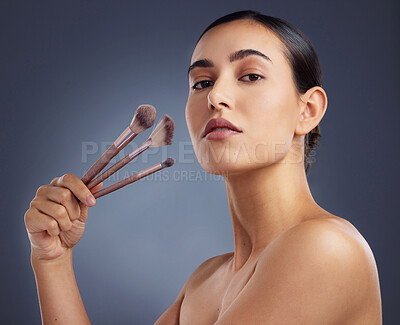Buy stock photo Studio shot of a beautiful woman holding up a set of make-up brushes