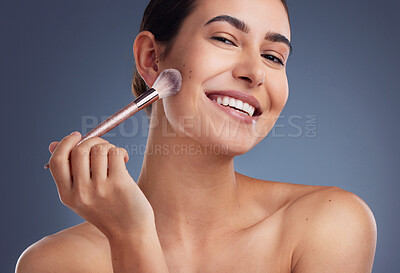 Buy stock photo Studio shot of a beautiful woman using a make-up brush on her cheek
