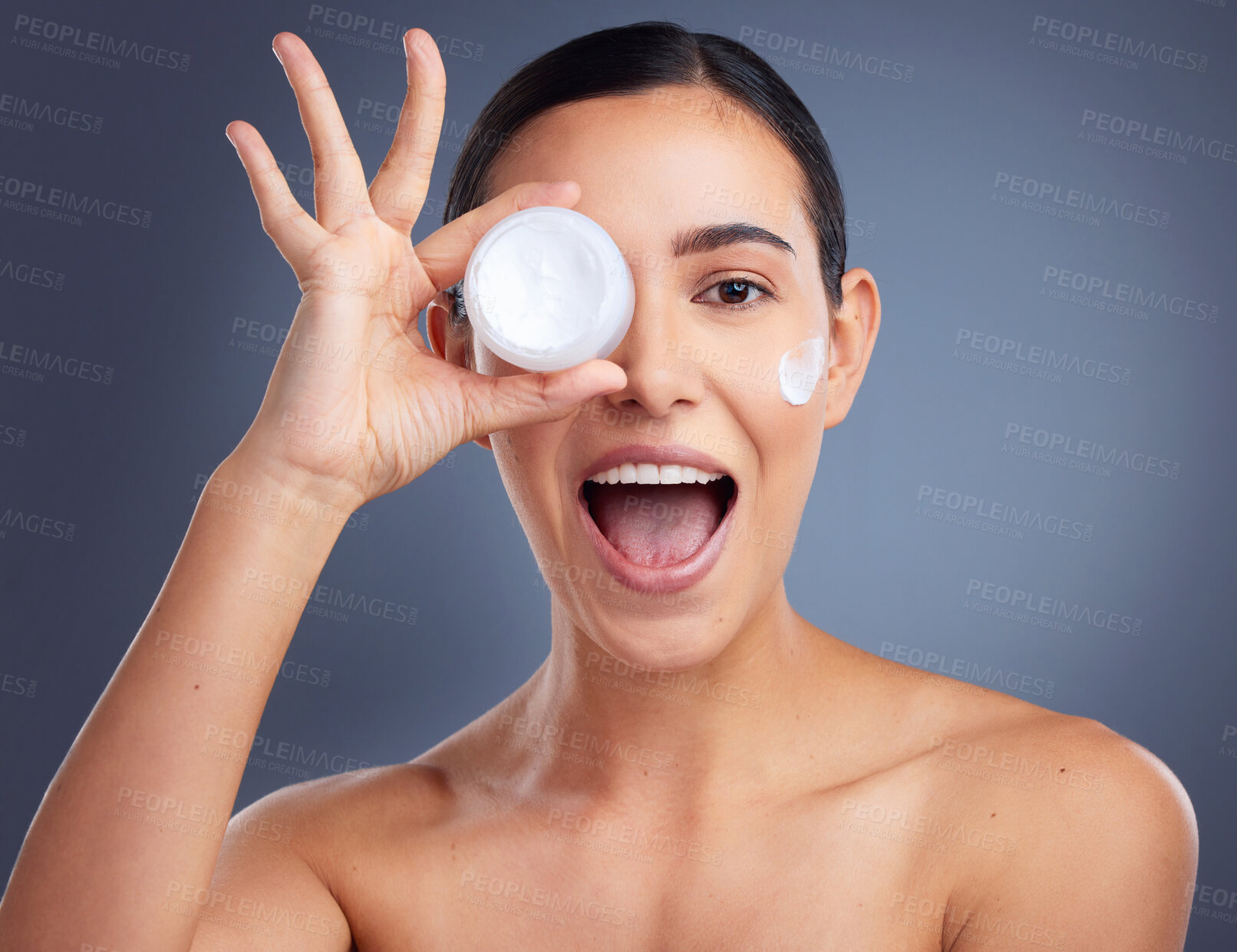 Buy stock photo Studio shot of a beautiful woman holding up a skincare product