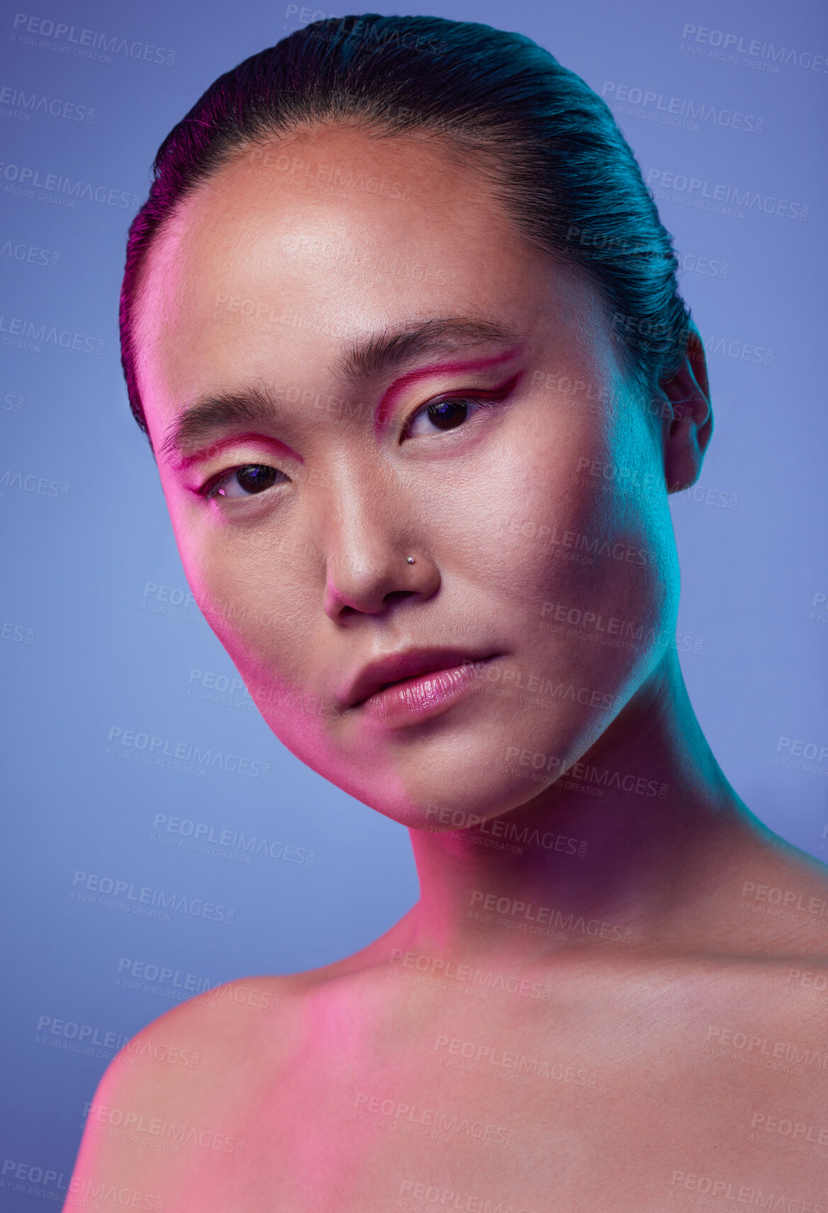 Buy stock photo Cropped shot of an attractive young woman posing in studio against a purple background