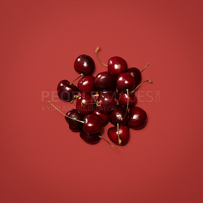 Buy stock photo Above, cherries and bunch in studio for gut health, nutrition and sweet healthy snack. Fresh fruit, share and stems on red background for vitamin C, balanced diet or aid for digestion on mockup space