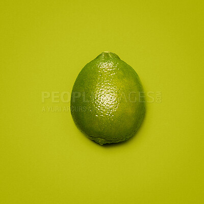 Buy stock photo Above, lime and fresh in studio for vitamin C, healthy eating and refreshing flavor for cocktails. Fruit, citrus and shine on green background for digestion aid, antioxidants or high acidity for diet