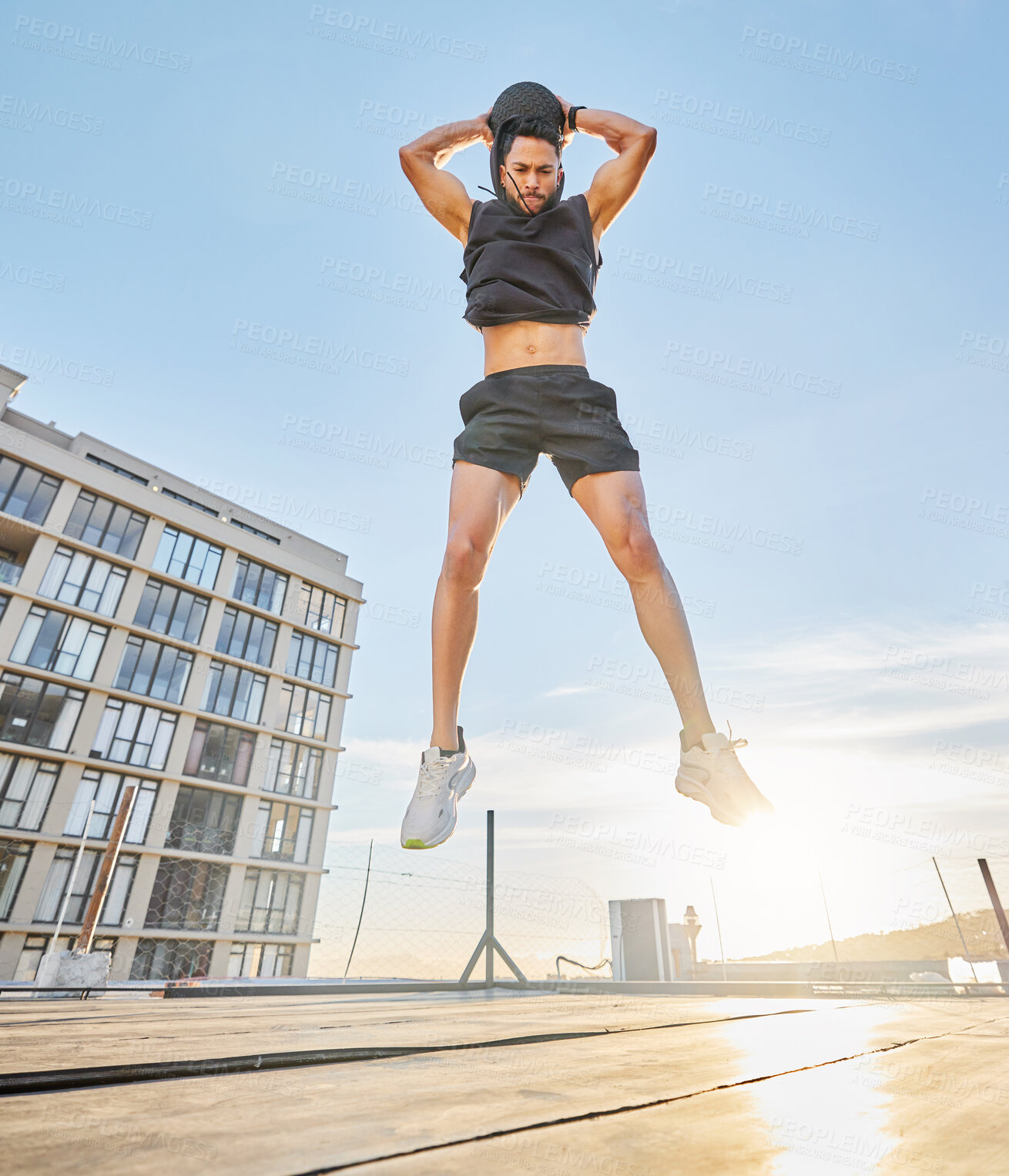 Buy stock photo Athlete, man and jump with medicine ball in city for fitness, cardio exercise and power training. Below, male person and leap with equipment for bodybuilding, strength workout and endurance challenge