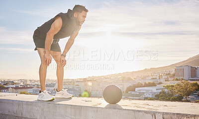 Buy stock photo Shot of a sporty young man out on a rooftop for a workout