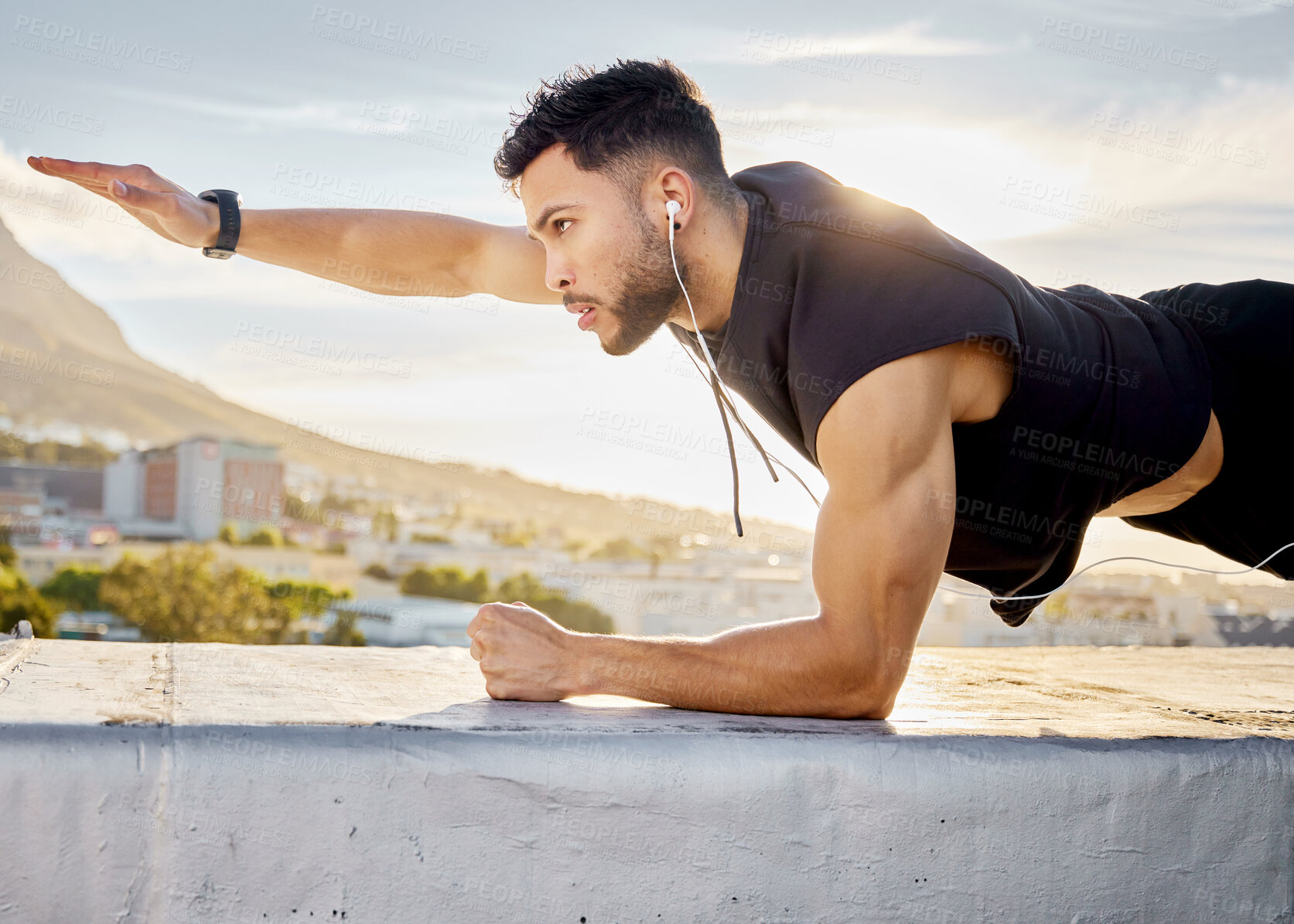 Buy stock photo Shot of a man doing a single-arm plank while on a rooftop