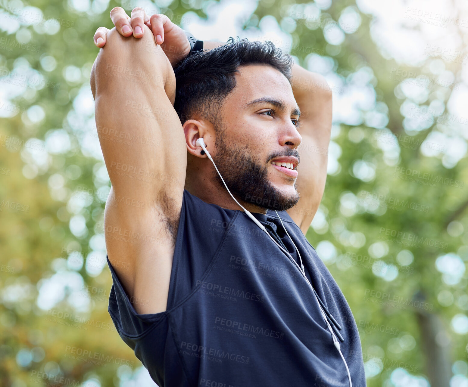 Buy stock photo Shot of a sporty young man stretching his arms while exercising outdoors