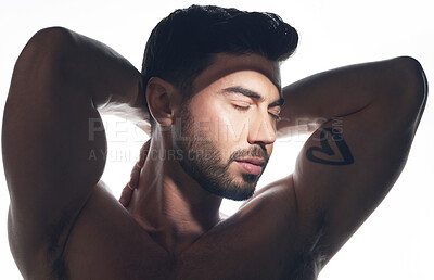 Buy stock photo Studio shot of a handsome young man posing against a white studio background