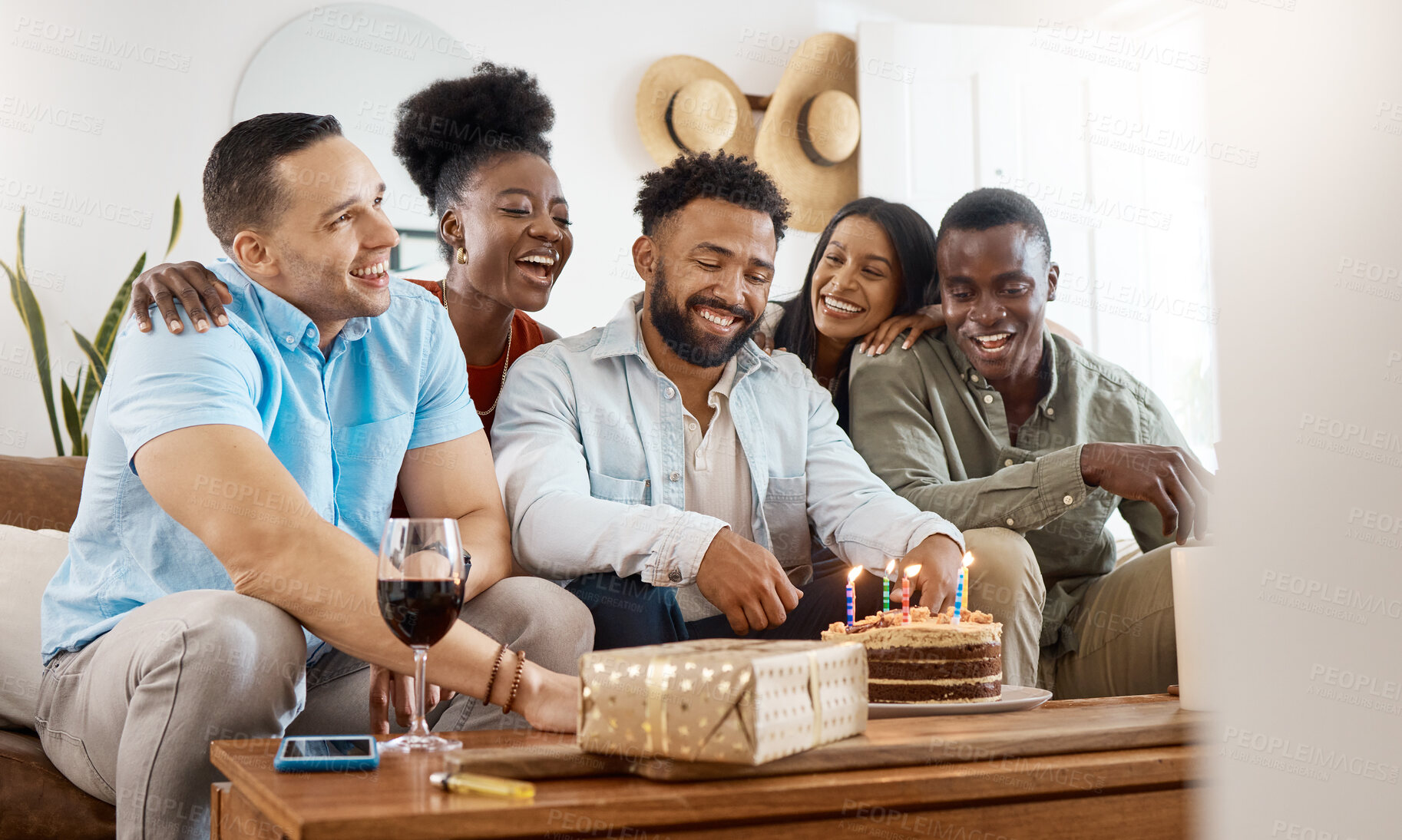 Buy stock photo Shot of a young man celebrating his birthday with friends at home