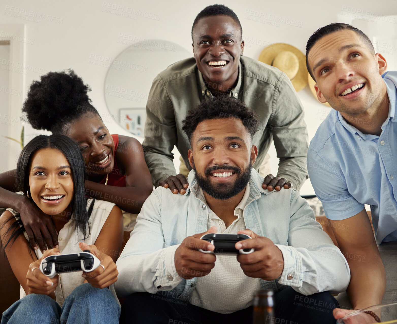 Buy stock photo Shot of two people playing video games while sitting at home with their friends
