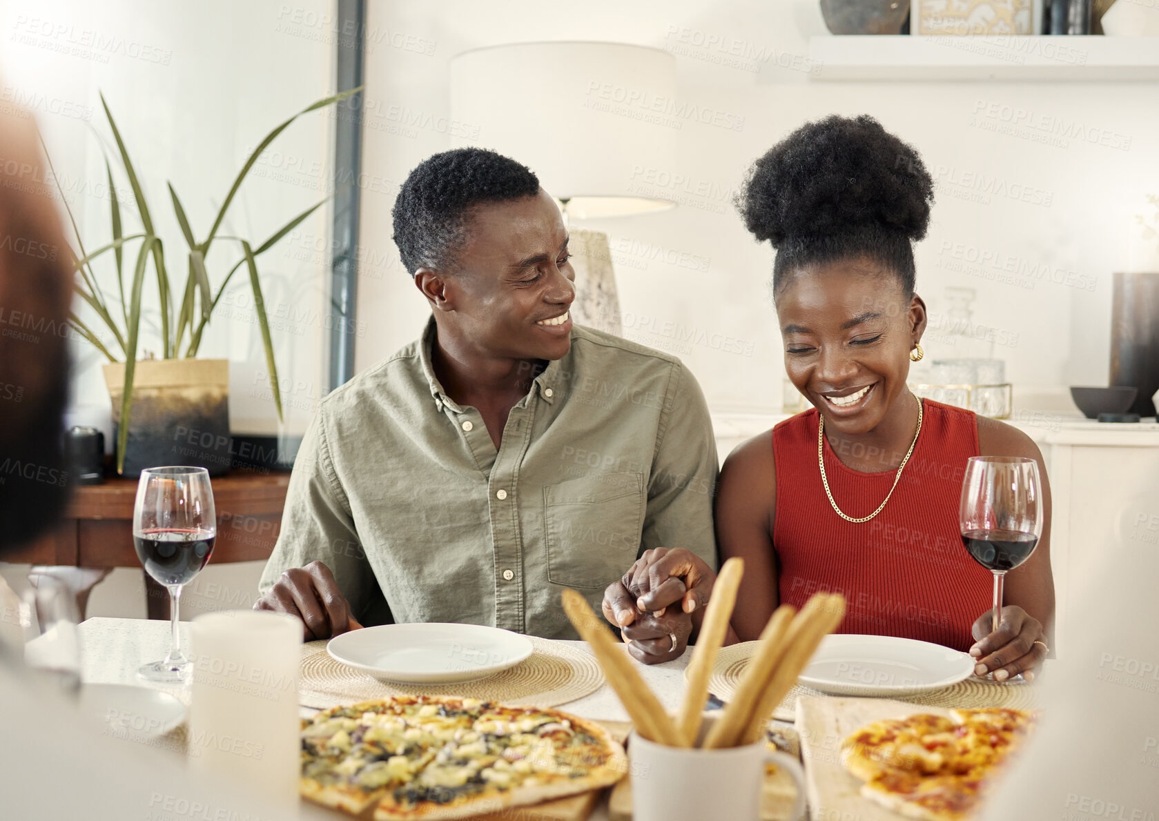 Buy stock photo Shot of an affectionate couple sitting together at a dining table