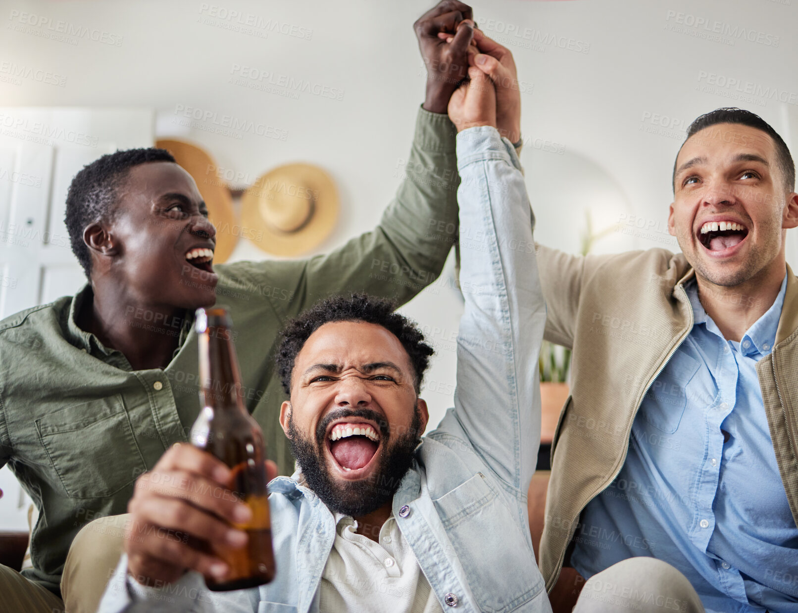 Buy stock photo Shot of three male friends looking cheerful while drinking beers and sitting together