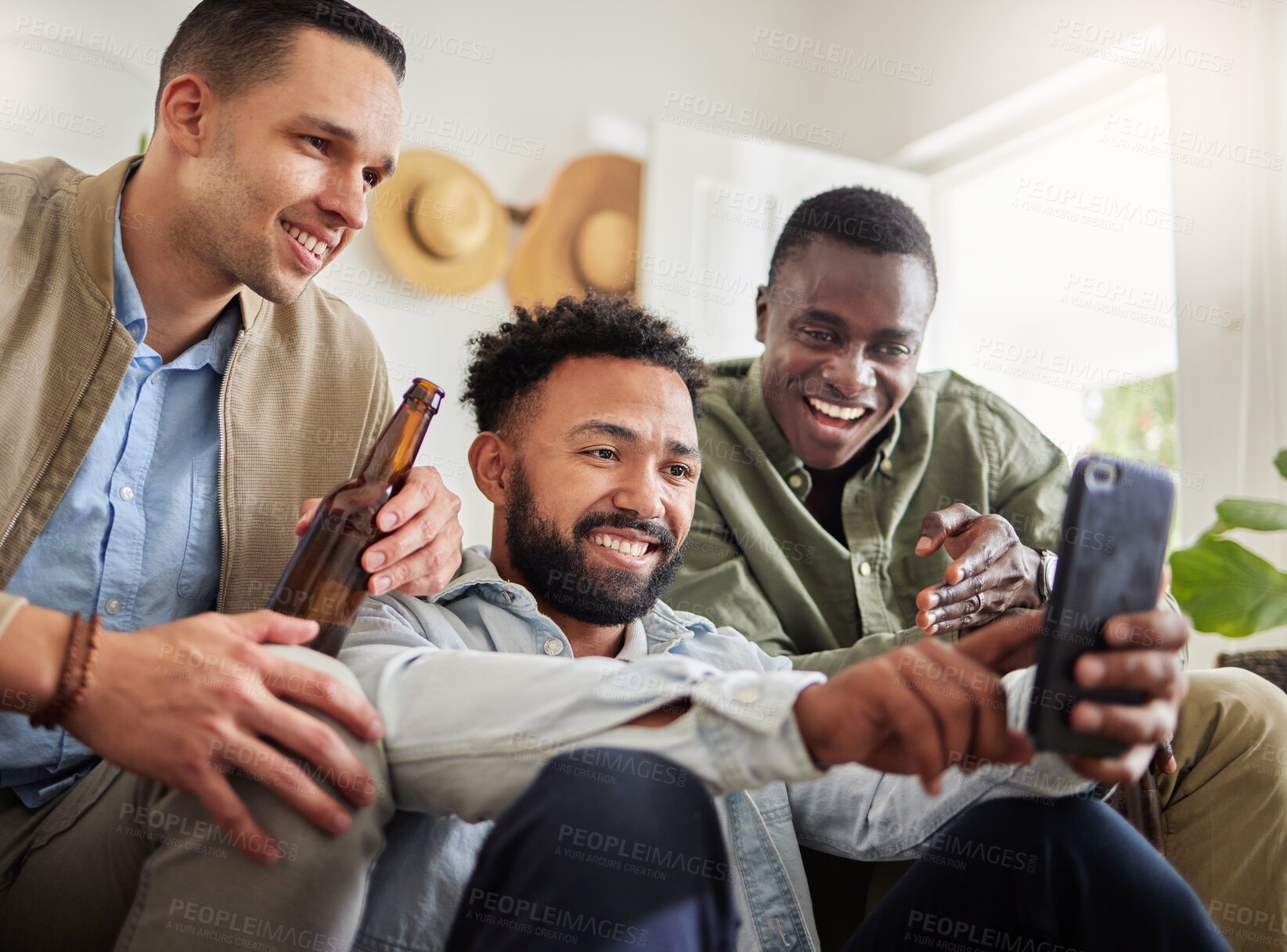 Buy stock photo Shot of a three male friends looking at something on a cellphone together