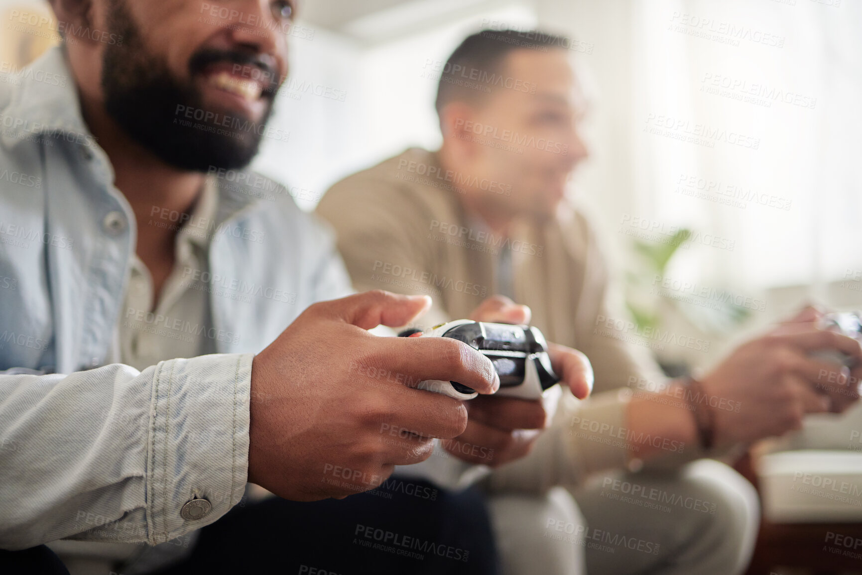 Buy stock photo Shot of two men playing video games while sitting on a couch together