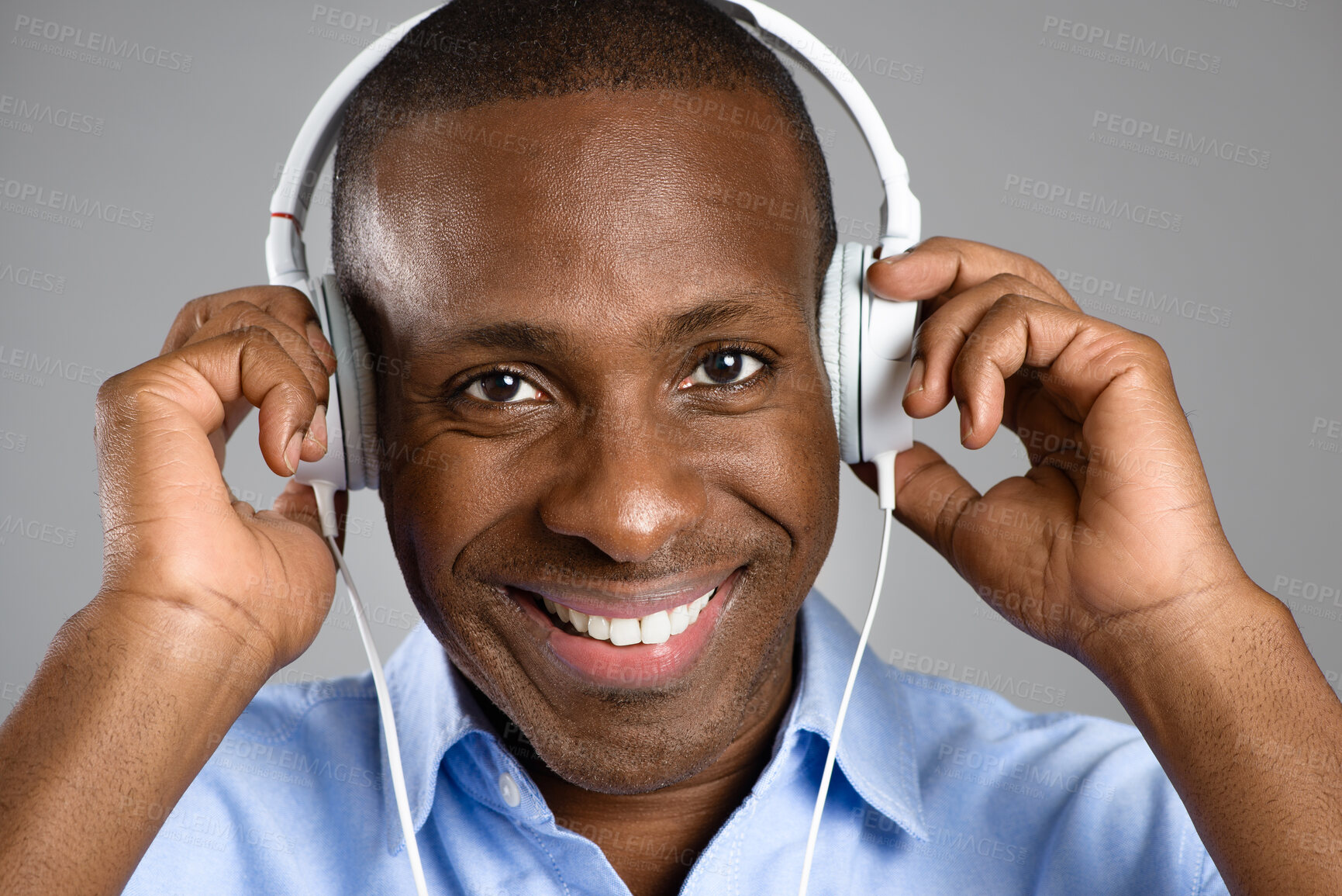 Buy stock photo Music, portrait of a black man with headphones and against studio background happy listening to radio. Podcast or audio, sound playlist or smile and face of African male person streaming media